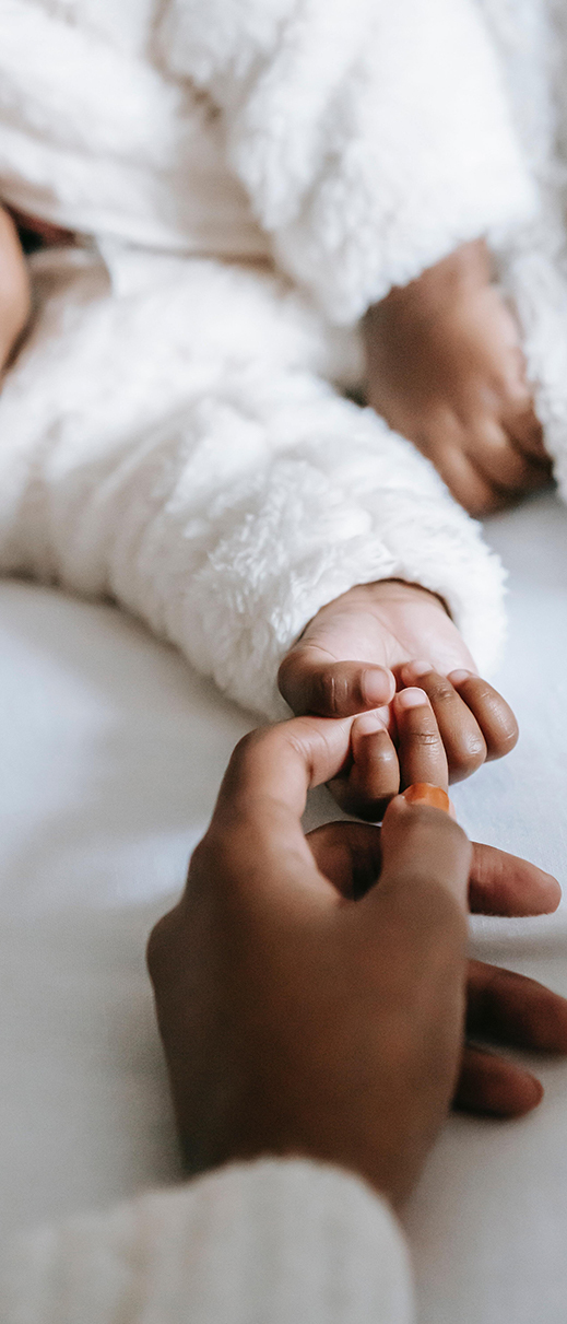 Femme tenant par la main un bébé qui dort sur un matelas made in france