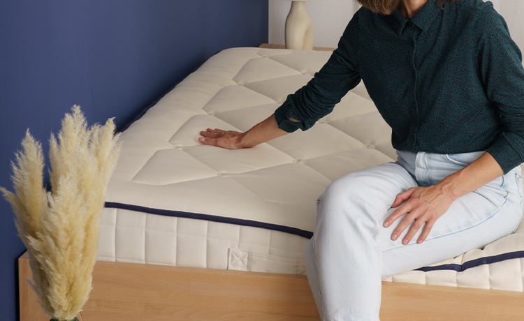 Personne testant le confort et le soutien d'un matelas en boutique.