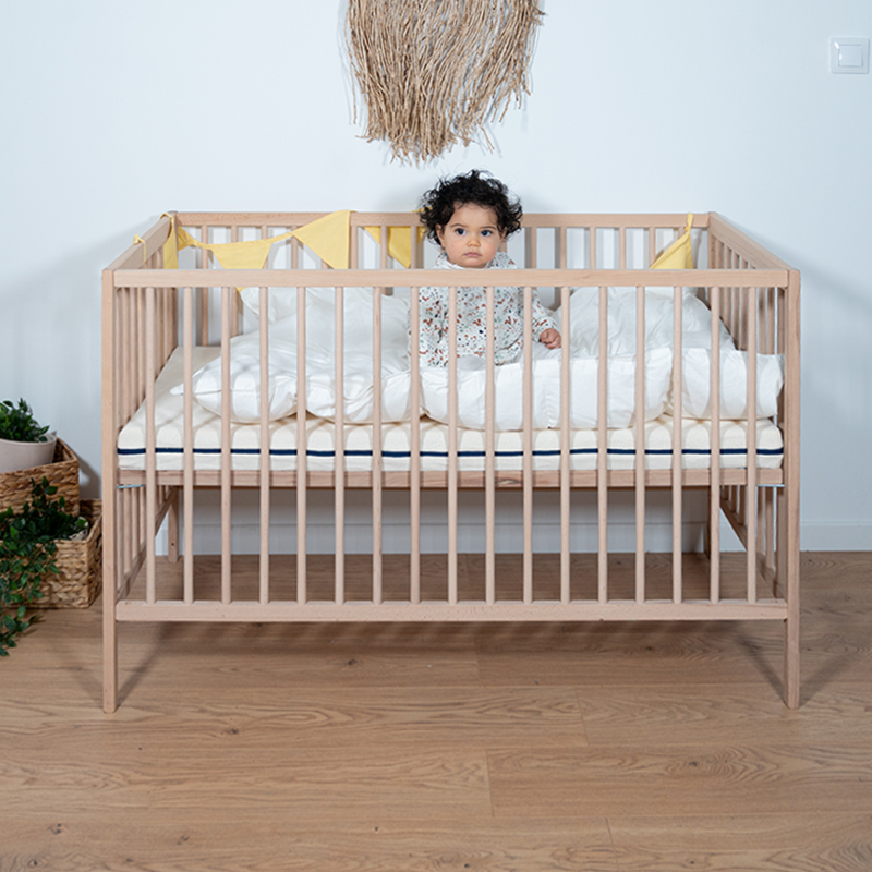 image représentant un enfant dormant dans un lit composé d'une parure de lit en coton bio gris