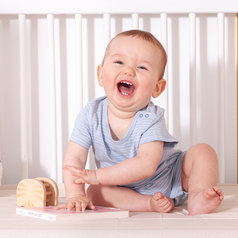 image représentant un enfant dans un lit a barreau, s'accrochant à ces derniers