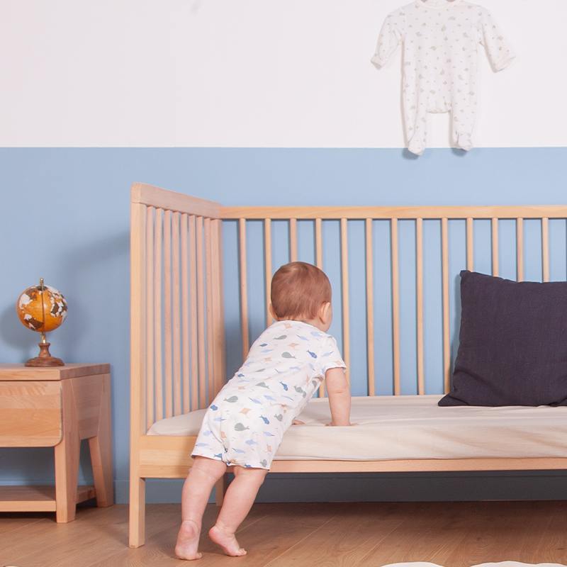 image représentant un enfant dormant dans un lit à barreau